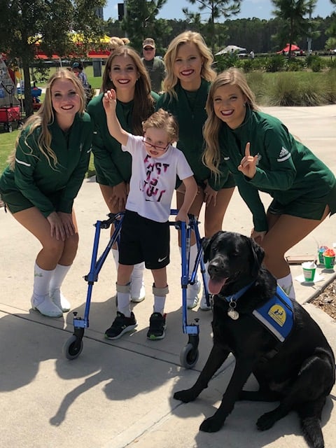Photo of USF cheerleaders surrounding Christopher and his service dog
